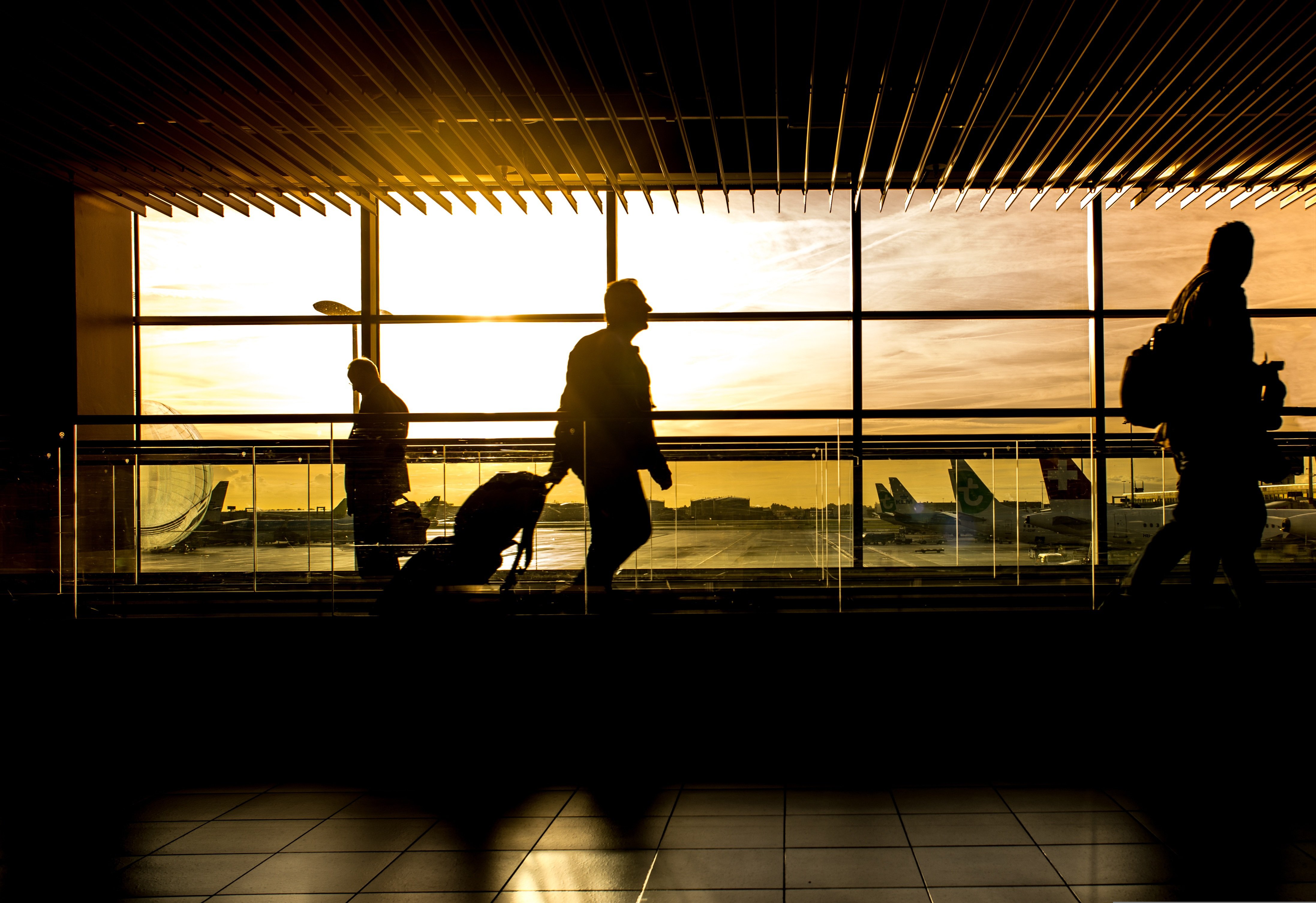 Passageiros num aeroporto ao pôr do sol